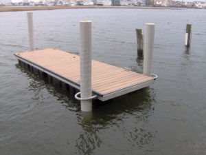 A floating dock with pile hoops in the water.